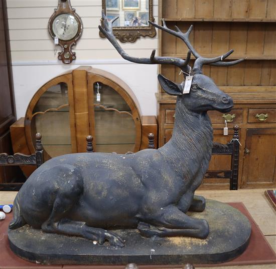 A large bronzed metal model of a recumbent stag H.88cm, W.100cm